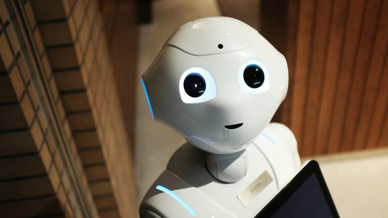 White humanoid robot face illuminated with blue light
